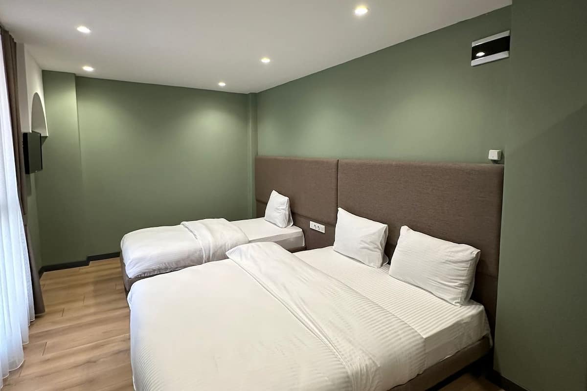 Habitación cuádruple Deluxe | Ropa de cama de alta calidad, minibar, caja fuerte y escritorio