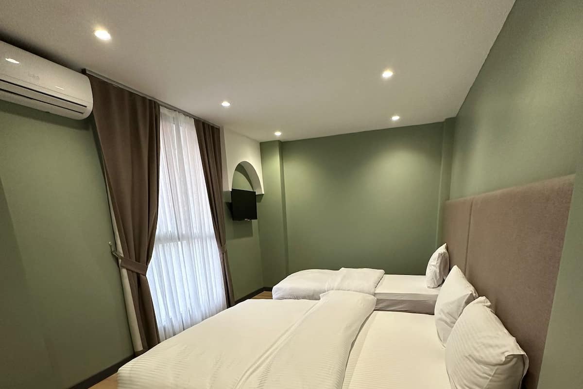 Habitación cuádruple Deluxe | Ropa de cama de alta calidad, minibar, caja fuerte y escritorio