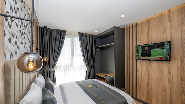 A modern hotel room with a large bed, a desk, and a television on the wall. - Heaven Inn Airport Hotel (Arnavutköy)