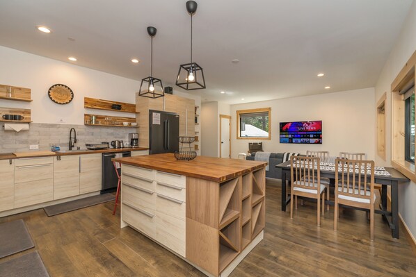 Une cuisine moderne avec des meubles en bois, un îlot central et des luminaires suspendus.