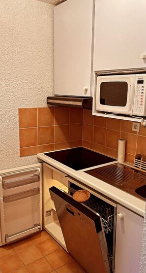 A compact kitchen with a microwave, oven, and dishwasher.