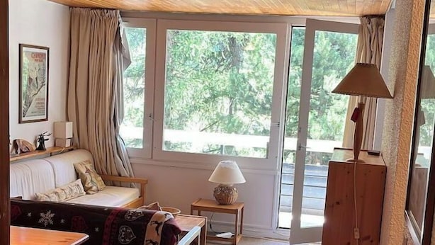 A cozy room with a wooden ceiling, a sofa, a table, and a lamp. - Vars: Very pretty mountain apartment. (Vars)
