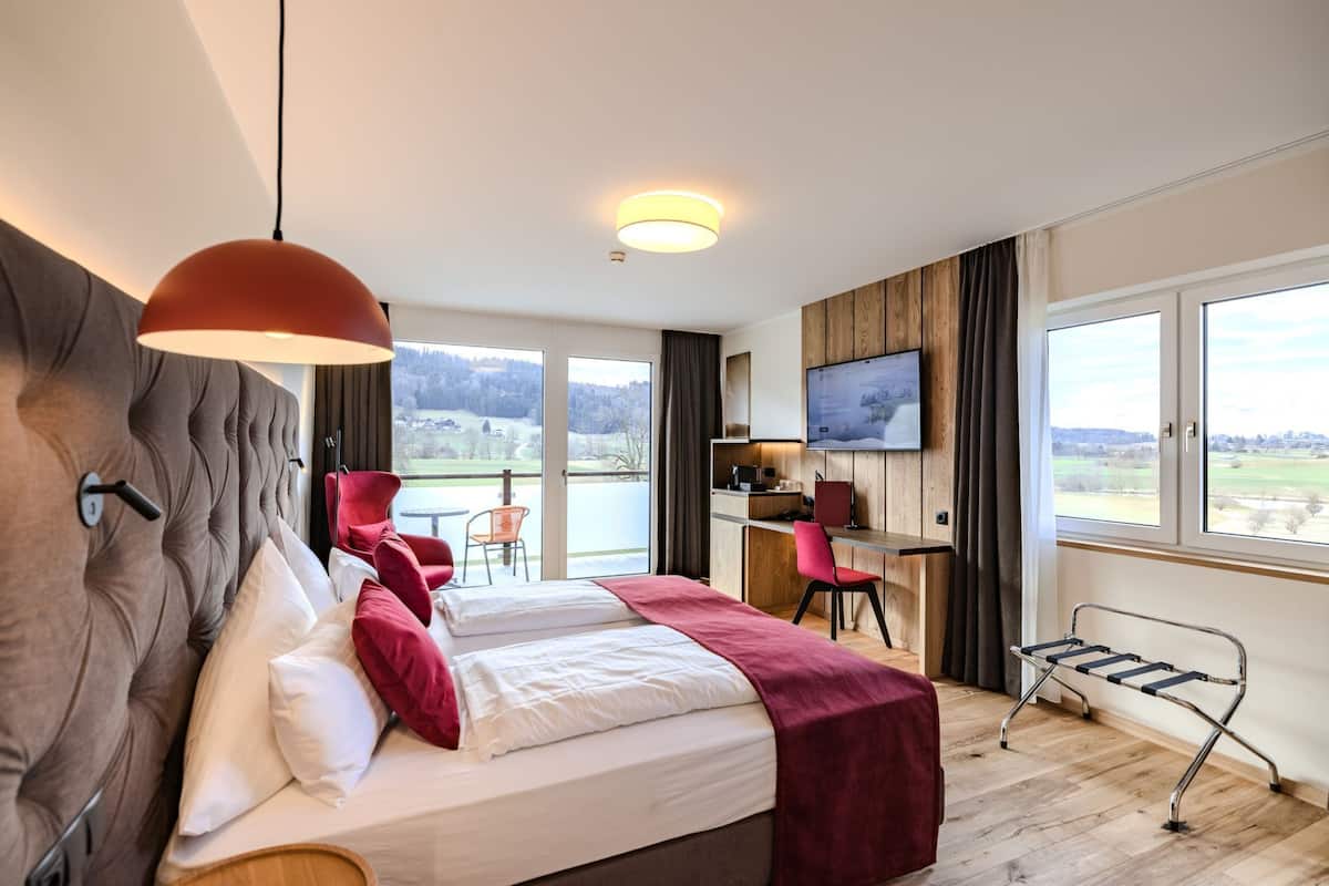 Une chambre d’hôtel avec un grand lit, un bureau, une télévision et une vue sur l’extérieur.