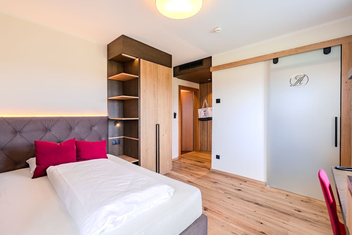 Une chambre moderne dotée d’un grand lit, d’étagères intégrées, d’une armoire et d’un petit coin cuisine.