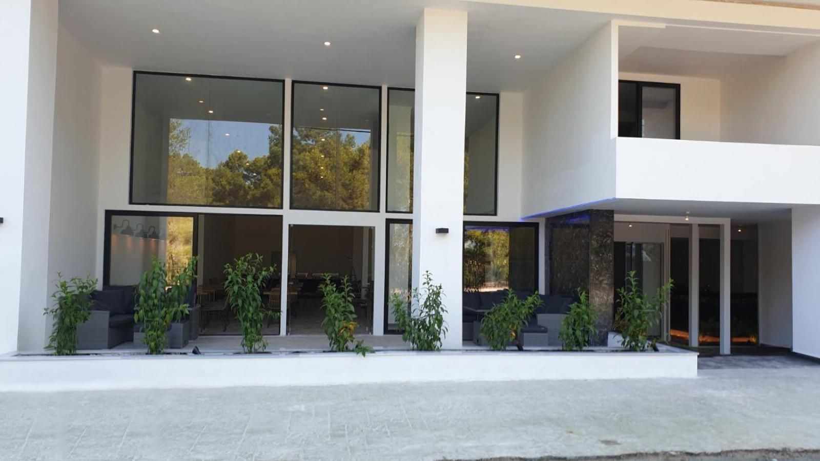 A modern building with large glass windows, a flat roof, and a minimalist design.
