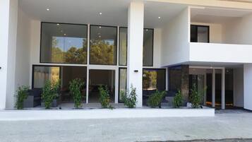 A modern building with large glass windows, a flat roof, and a minimalist design.