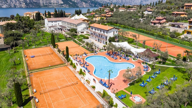 Un complexe hôtelier doté d’une grande piscine, de courts de tennis et offrant une vue sur les montagnes.