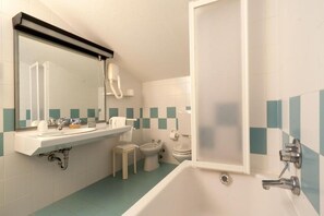 Une salle de bain équipée d’un lavabo, d’un miroir, de toilettes, d’un bidet et d’une baignoire.