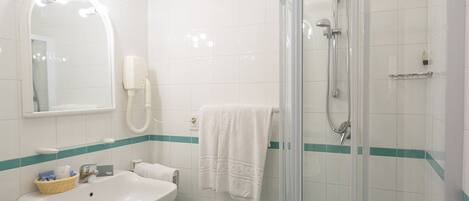 Un baño con lavamanos, espejo y ducha.