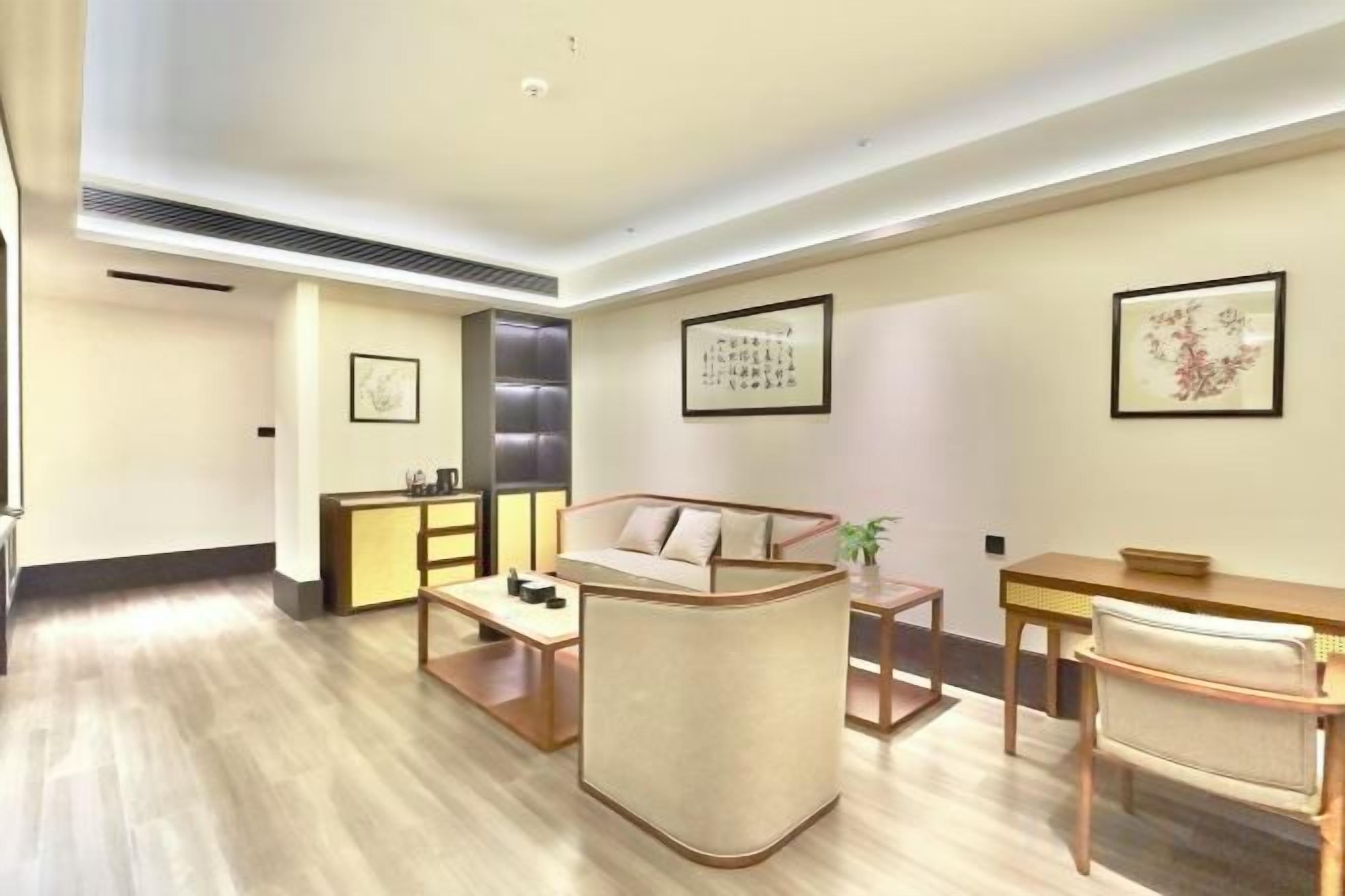 A modern living room with a sofa, coffee table, and a dining area with chairs.