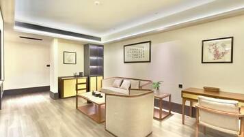 A modern living room with a sofa, coffee table, and a dining area with chairs.