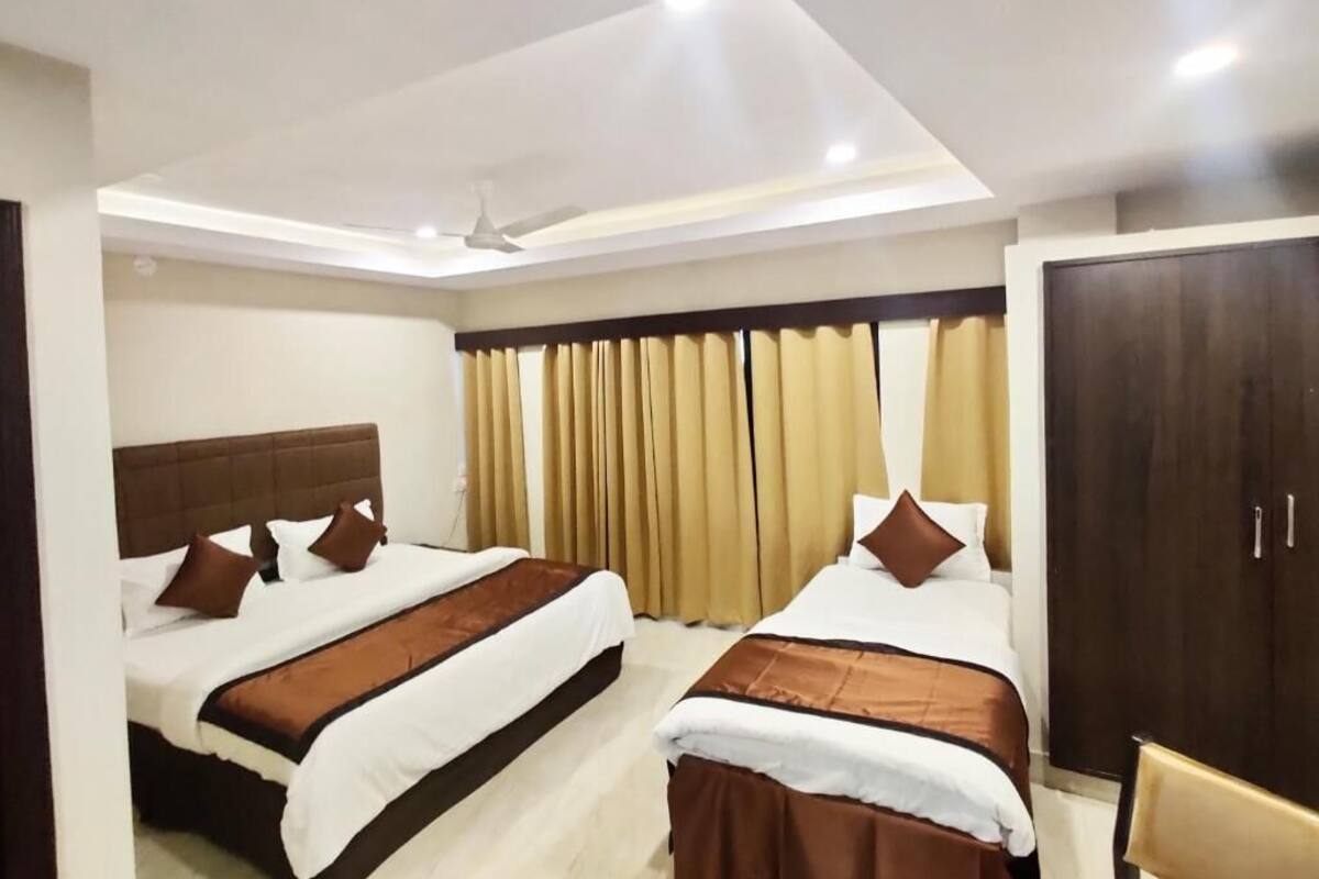 Habitación de hotel con dos camas, un armario y un ventilador de techo.