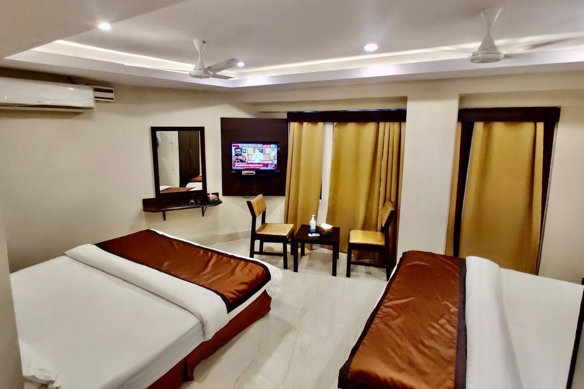 Una habitación de hotel con dos camas, un televisor, un escritorio y una silla.