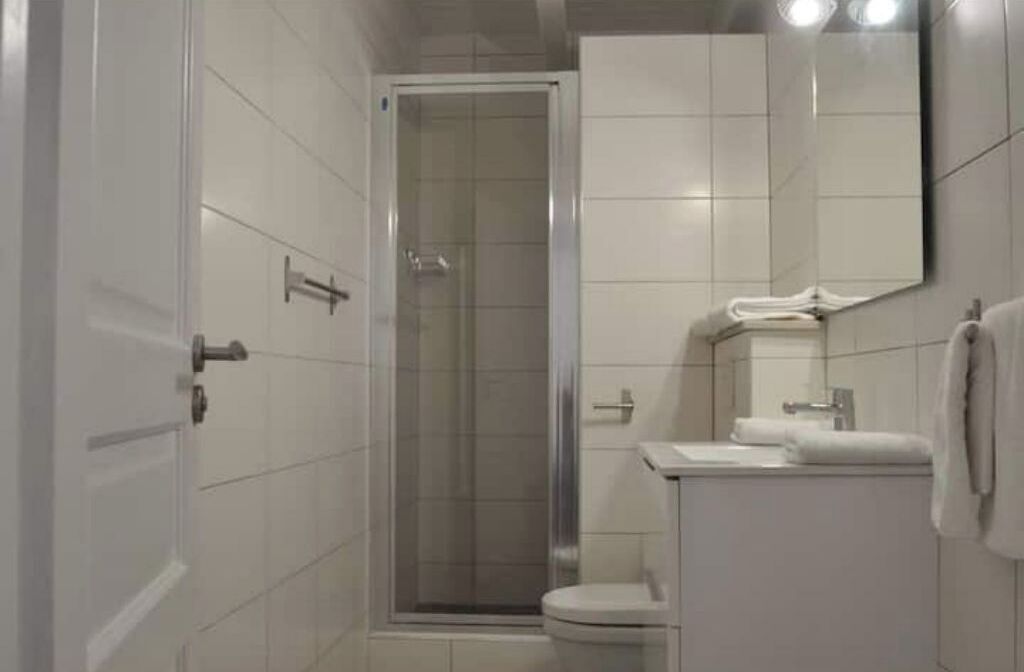 A bathroom with a shower, toilet, and sink.