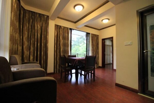 A hotel room with a dining area, a large window with curtains, and a door leading to another room. - Hongyezhai Ecological Leisure Villa (Hengyang)