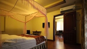 A room with a bed, a bedside table, a chair, and a door leading to another room. - Hongyezhai Ecological Leisure Villa (Hengyang)