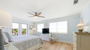A bedroom with a bed, a television, a desk, and a chair.