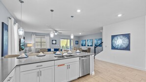 A modern kitchen with a central island, white cabinetry, and a built-in dishwasher. - Professionally Purpose Built Vacation Oasis- New Discounts Just Applied! (Davenport)