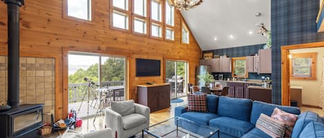 Un amplio salón con un sofá grande azul, una chimenea y un telescopio.