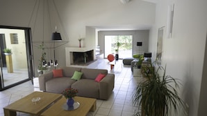 Un salón espacioso con sofá, mesa de centro y chimenea.