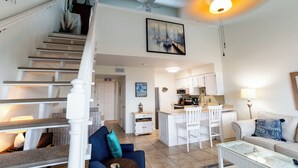 Un vaste espace de vie comprenant un escalier, une cuisine et un coin repas.