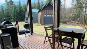 A wooden deck with a table and chairs, a barbecue grill, and a fire extinguisher. - Ashford cabin,Mt. Rainier view. Private river access, 17 acres, 5 mi to MRNP (Ashford)