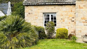 Ein Steinhaus mit kleinem Fenster und Schornstein.