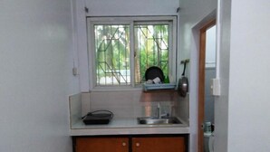 Uma cozinha pequena com janela, pia e bancada.