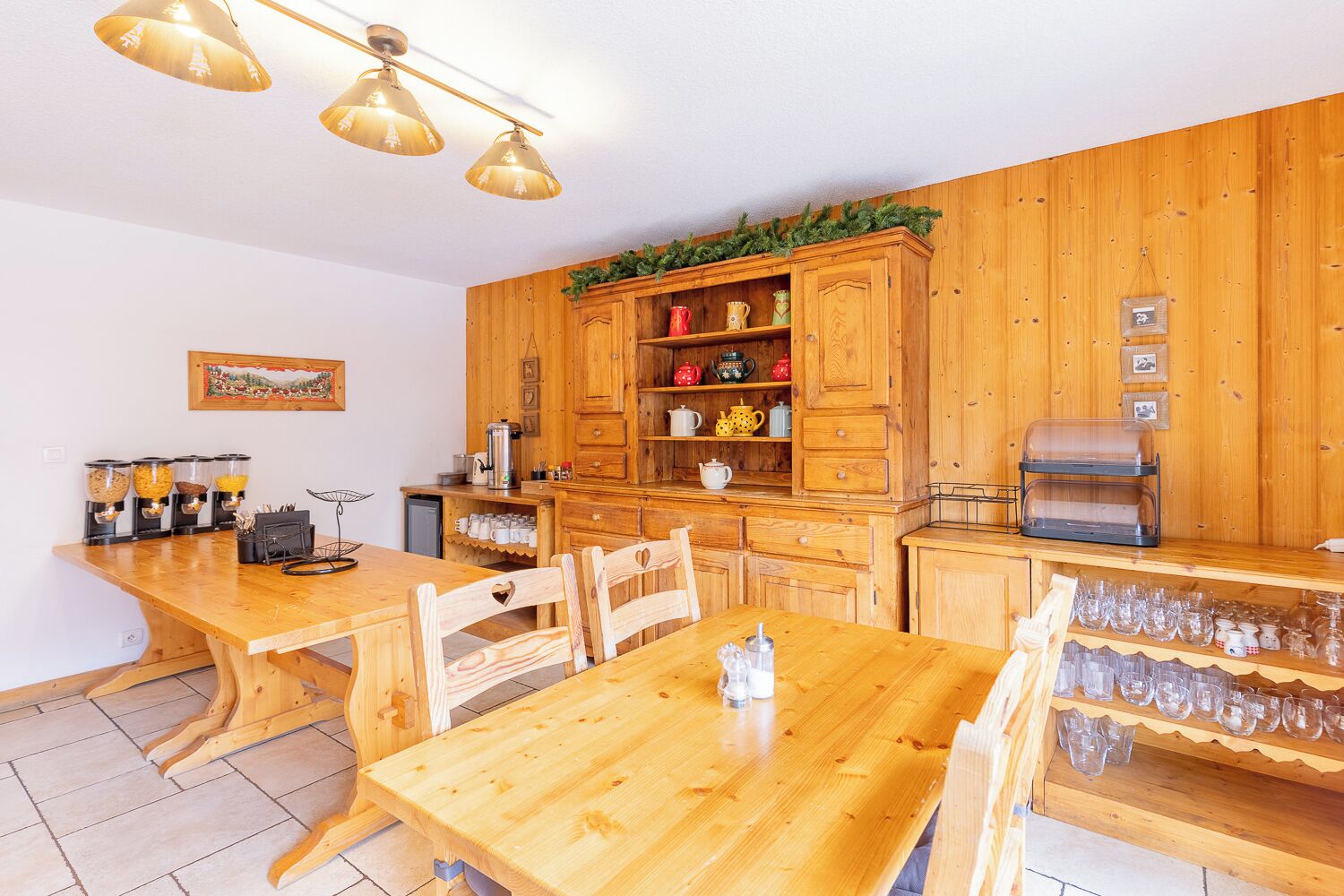 Une cuisine en bois avec une table à manger, des chaises et divers appareils de cuisine.