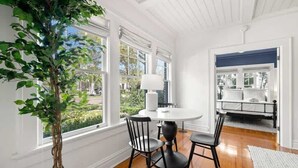A dining area with a round table, four chairs, and a potted plant. - The Adaline #1 -  Luxury Hyde Park Apt Near Bayshore (Tampa)