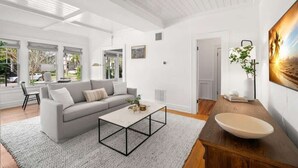 Una sala de estar moderna con sofá, mesa de centro y un cuadro grande en la pared.