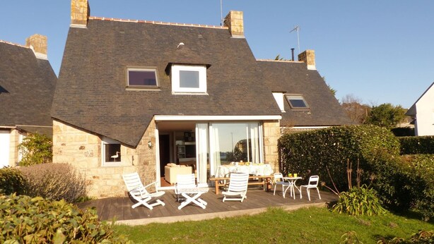A two-story house with a sloped roof, a patio with outdoor furniture, and a garden area. - House near Presses beach in Saint Philibert (Saint-Philibert)