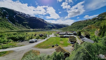 A remote village with traditional houses, a clear sky, and a lake in the background.
