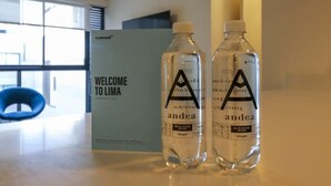 Two water bottles labeled 'andea' on a table in a room with a 'WELCOME TO LIMA' sign. - w* | Art Deco 1BR in Barranco (Barranco)