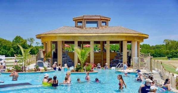 A swimming pool with a gazebo-like structure in the background.