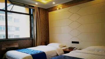 A hotel room with two beds, a window, and a modern wall design.