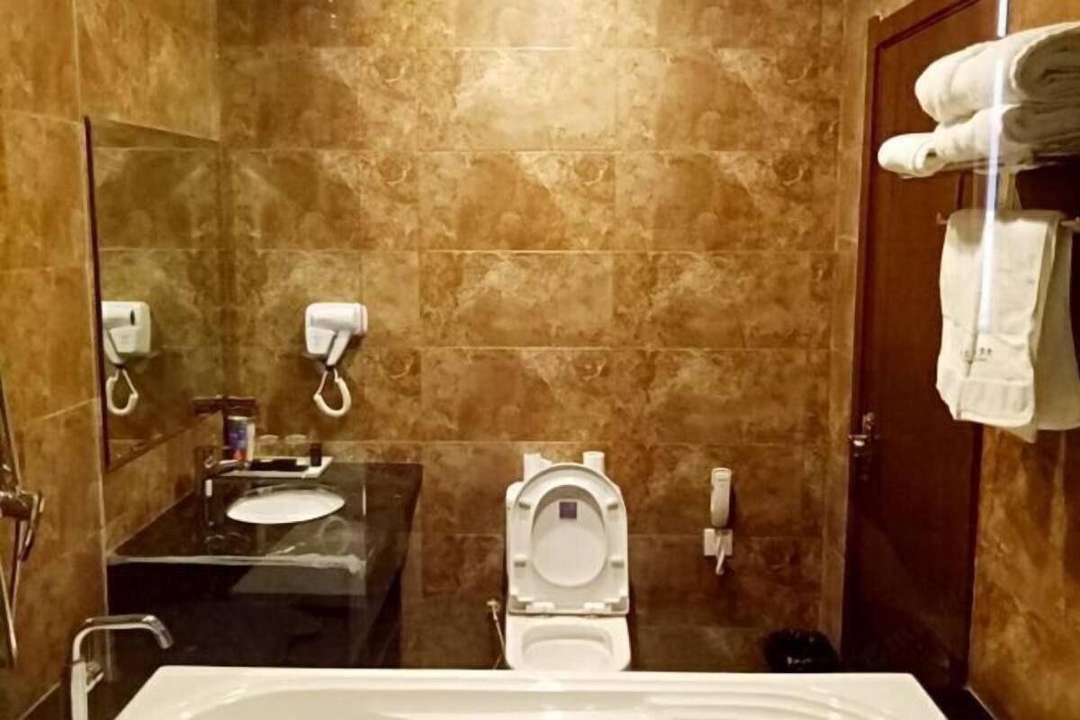 Kylpyhuone, jossa on kylpyamme, pesuallas, wc ja pyyheteline.