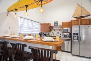 Enjoy cooking in this well-equipped kitchen with a central island, stainless steel appliances, and ample storage.