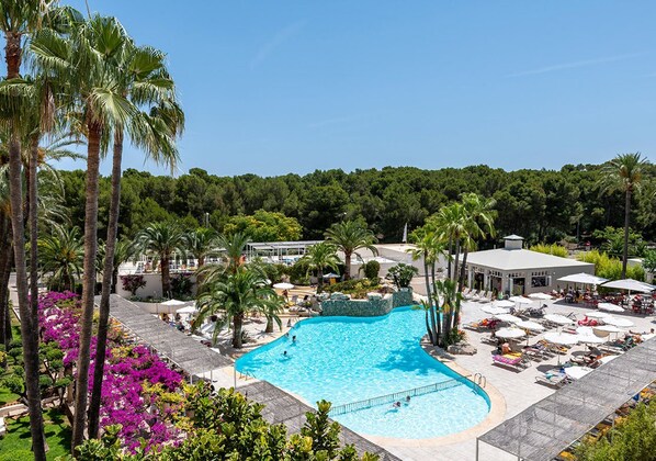 A large outdoor swimming pool surrounded by palm trees and lounge chairs. - Intelier Rosella Hotel by Intelier Hotels & Suites (Sant Llorenc des Cardassar)