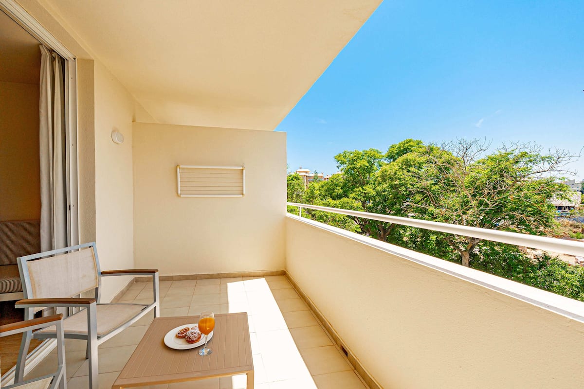 Ein Balkon mit Tisch, Stühlen und einer Schüssel Essen.
