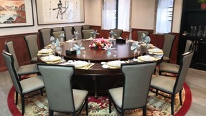 A conference room with a round table, eight chairs, and a floral centerpiece. - Shangpin Huangting Kangyang Hotel (Ningxiang)