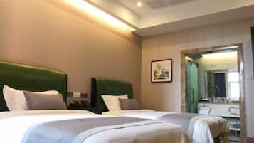 Habitación de hotel con dos camas, un espejo grande y un cuadro en la pared.