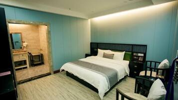 Un dormitorio moderno con cama, mesita de noche, silla y un escritorio pequeño.