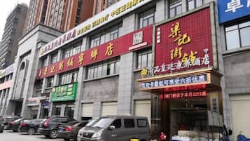 A building with multiple commercial establishments, including a store with a red sign and a blue sign.