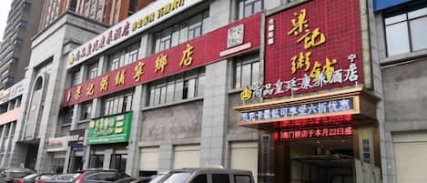 A building with multiple commercial establishments, including a store with a red sign and a blue sign.