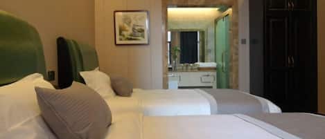 Habitación de hotel con dos camas, un espejo, un tocador y un armario.