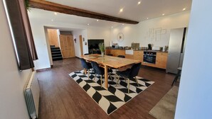 Une cuisine moderne avec des meubles en bois, un four encastré et un réfrigérateur.