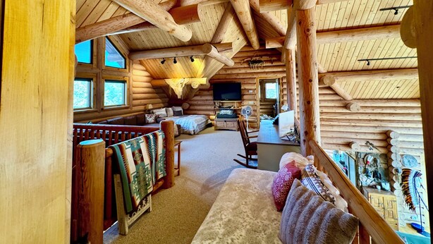 A log cabin interior with a cozy living area, a dining table, and a television. - Gorgeous Log Cabin estate with hot tub, views, privacy and sauna ! (Durango)