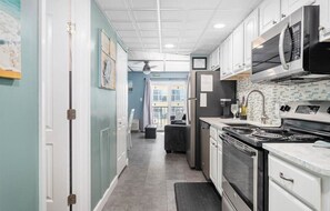 Enjoy cooking in this well-equipped kitchen with a gas range, microwave, and refrigerator.
