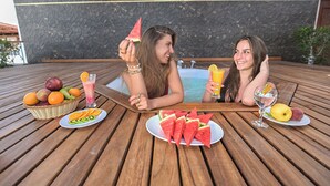 Two people relaxing by a wooden pool table with fruit and drinks. - Swiss Wellness Dive Resort (Hurghada)